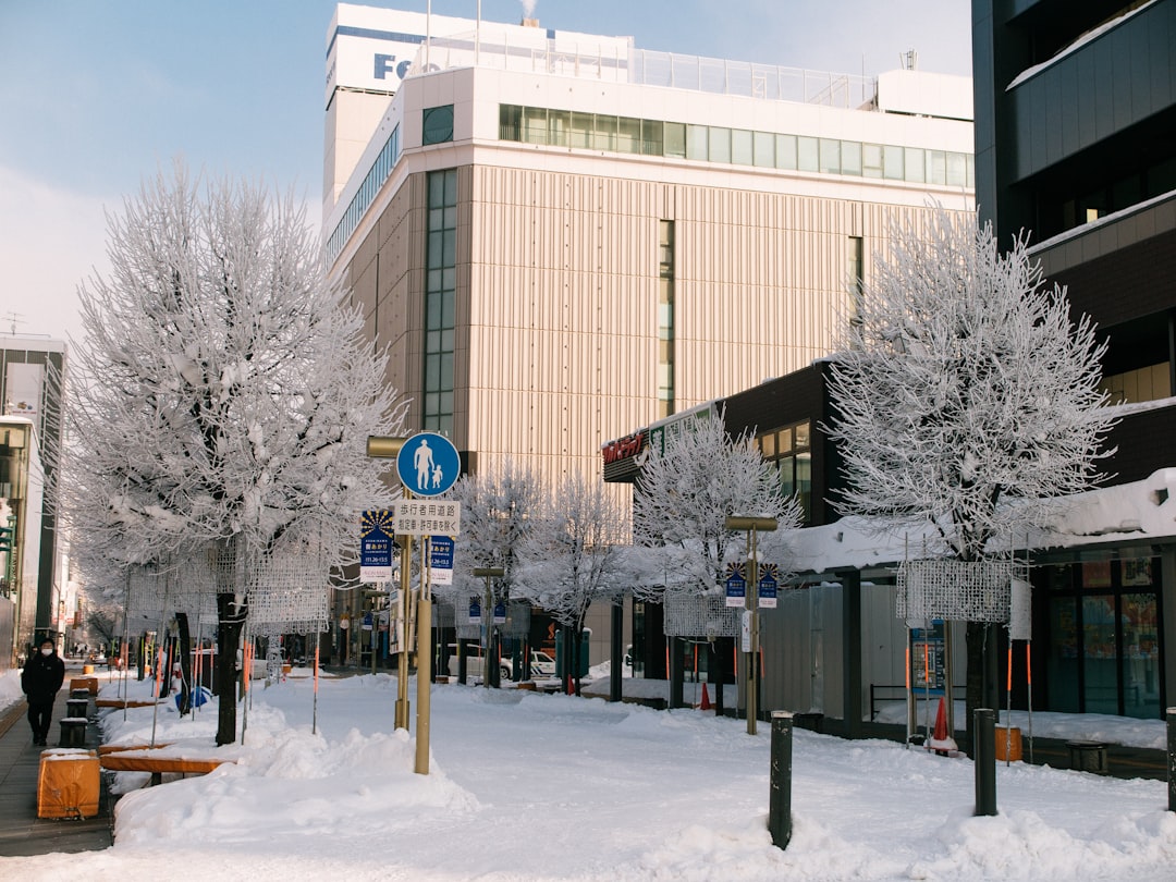 a city street covered in snow next to a tall building