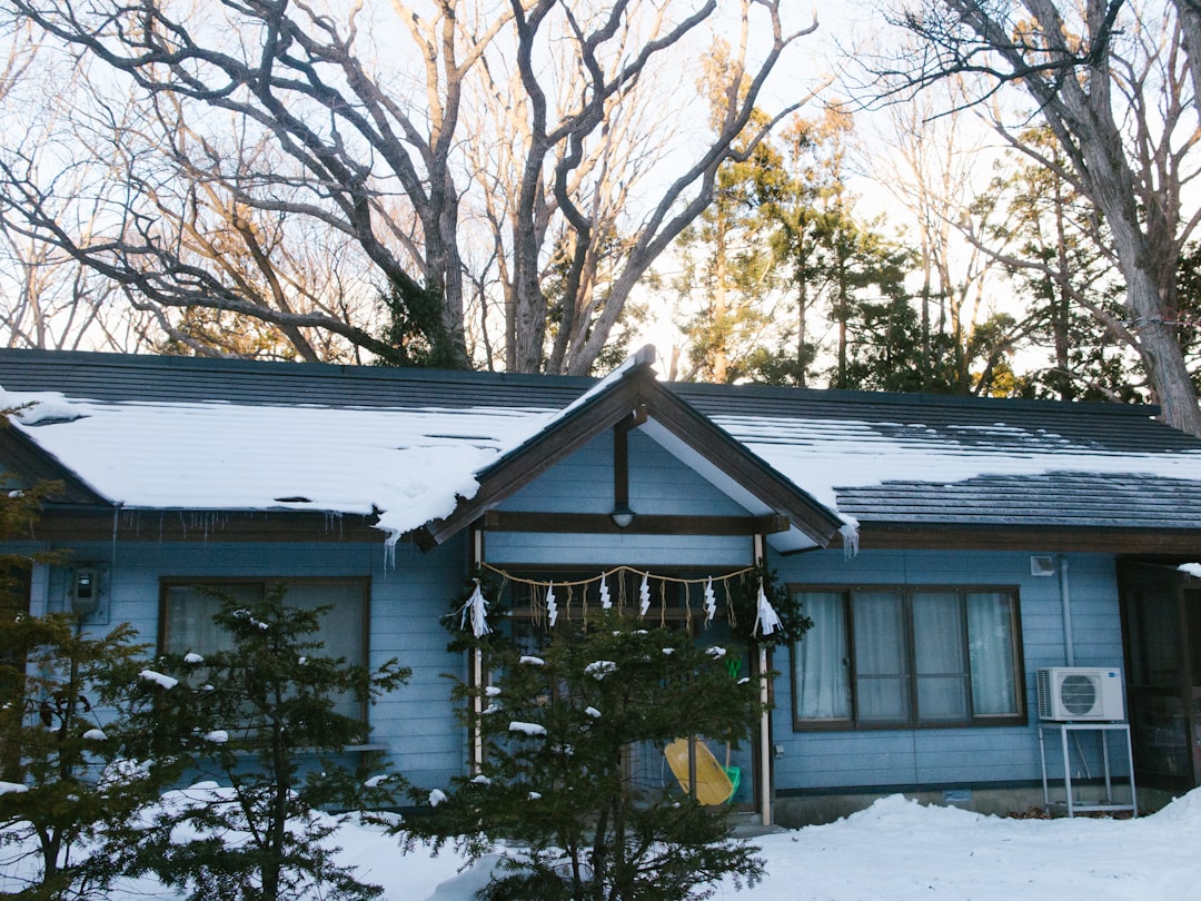 a blue house with snow on the roof