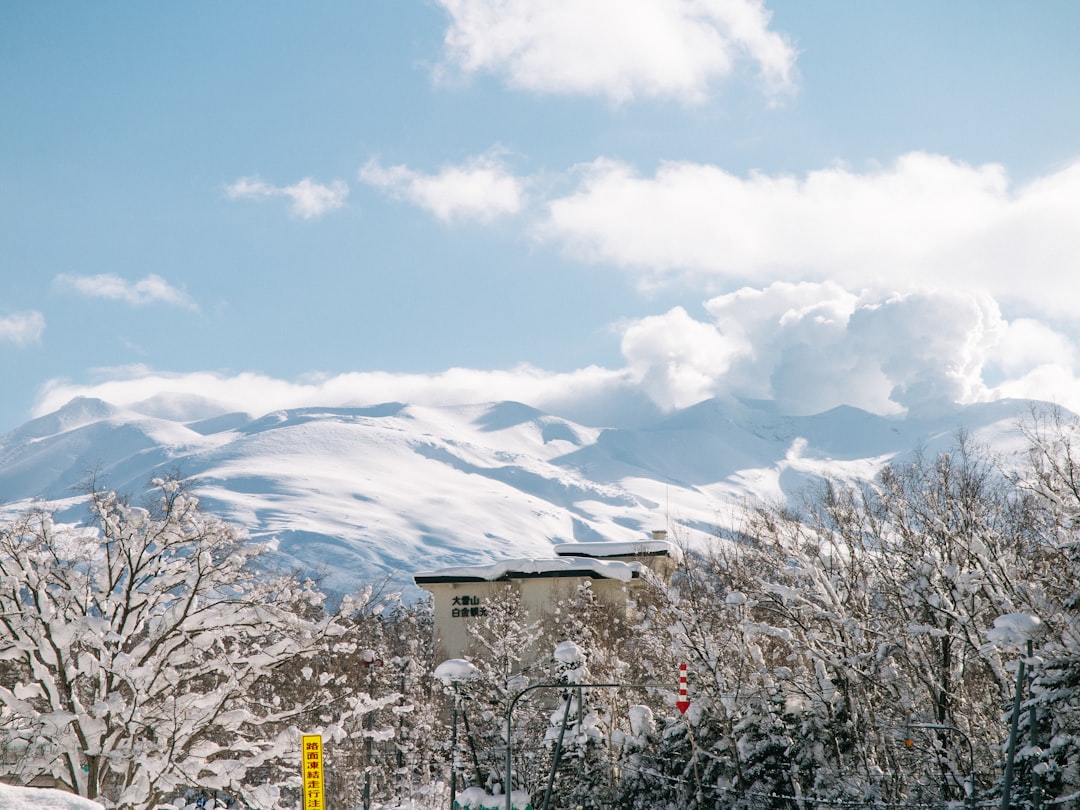 a snow covered mountain with a building in the foreground