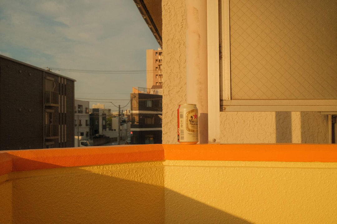 a can of beer is sitting on the ledge of a building