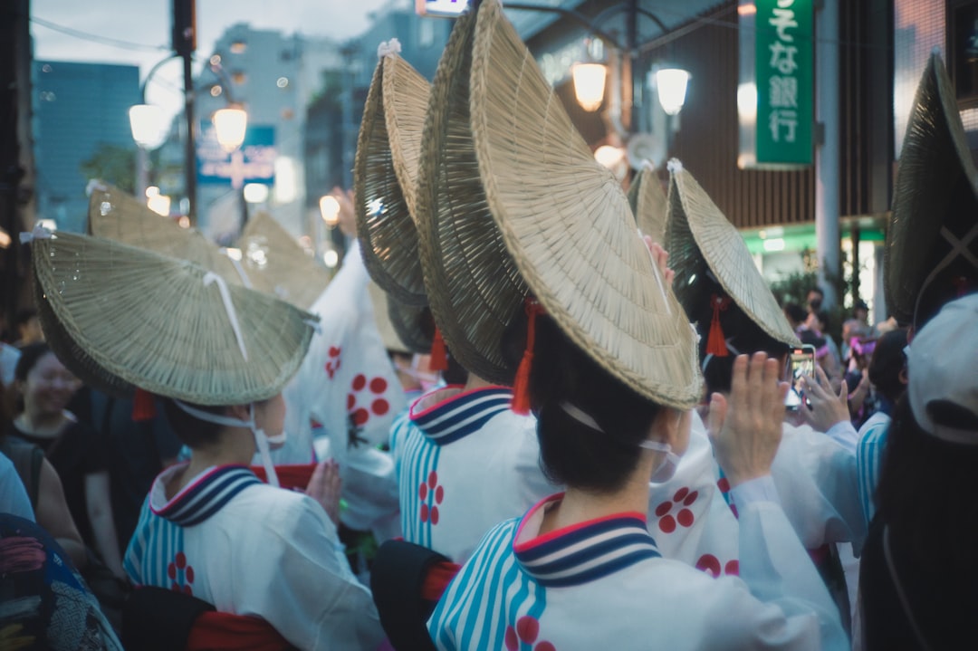 A group of people wearing hats walking down a street