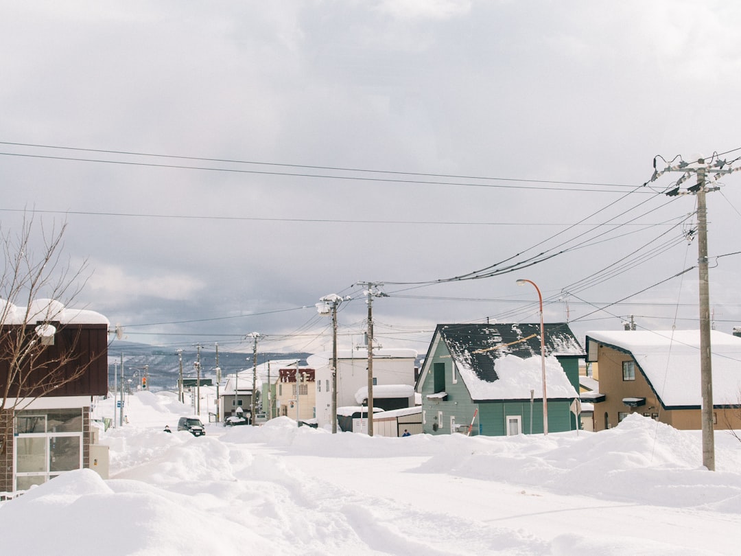 a snow covered street with power lines above it