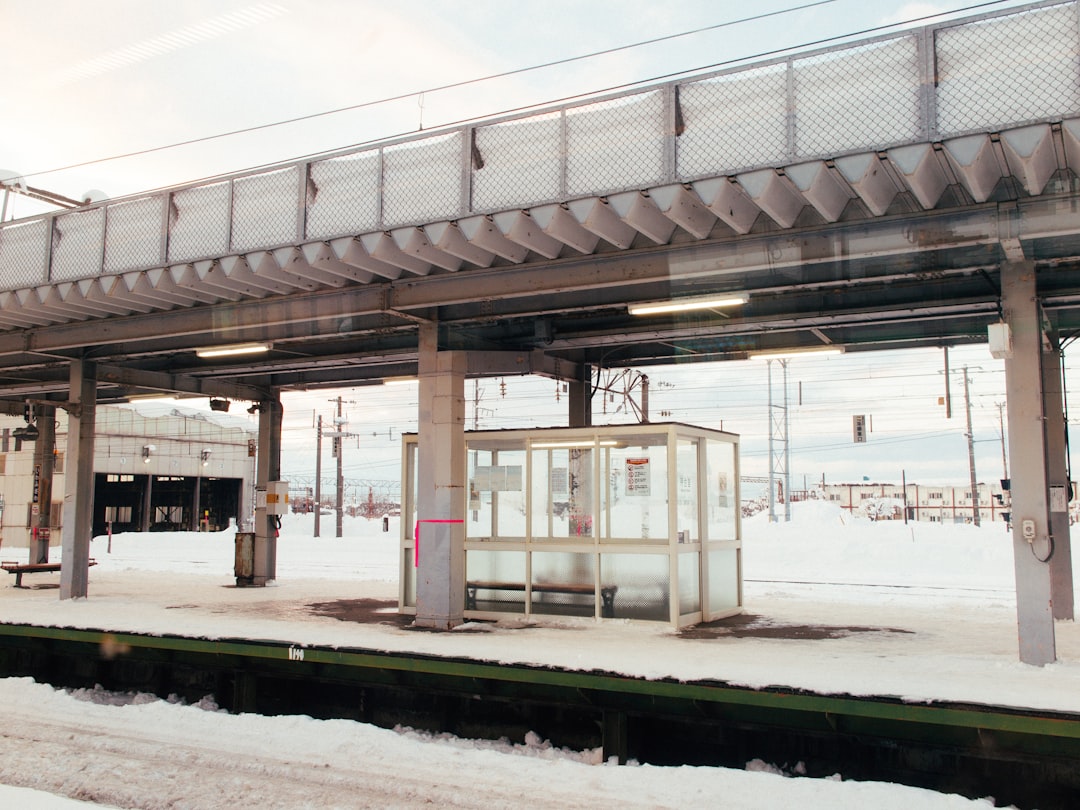 a train station covered in snow next to a train track