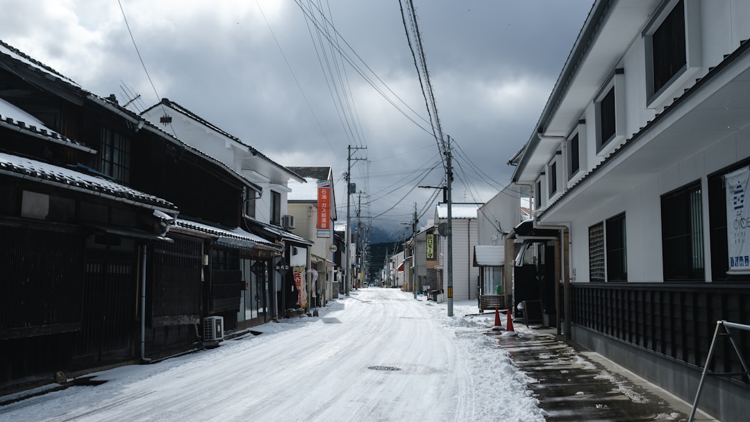 a snowy street lined with buildings and power lines